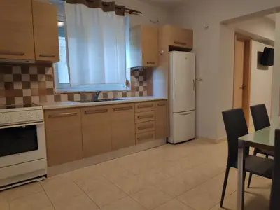 a kitchen with a white refrigerator and a table at Xenia's countryside guesthouse in Agia Marina Nea Kydonias