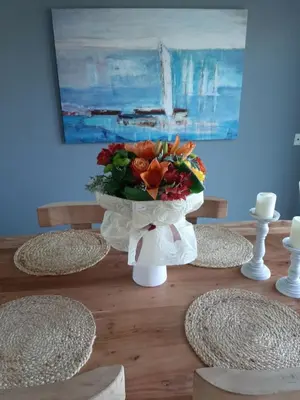 a vase with a bouquet of flowers on a table at koukounari apartment in Chania city center in Chania Town