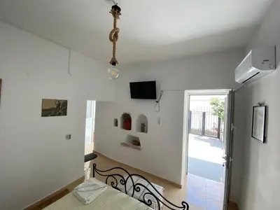 a bedroom with a bed and a tv on the wall at Casa Elafonisi N1- 10min from the beach in Plokamianá