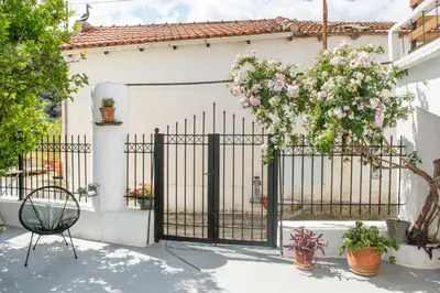 a gate to a white house with flowers on it at Casa Elafonisi N1- 10min from the beach in Plokamianá
