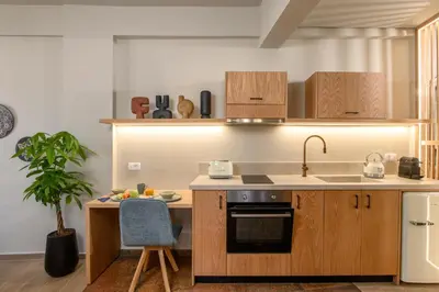 a kitchen with wooden cabinets and a sink and a table at Casbah Boutique Hotel in Palaiochóra