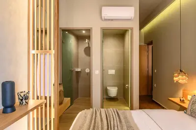 a bedroom with a bed and a bathroom with a toilet at Casbah Boutique Hotel in Palaiochóra