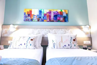 a bedroom with two beds and a painting on the wall at Sonio Villas - Que Bella Collection in Plataniás