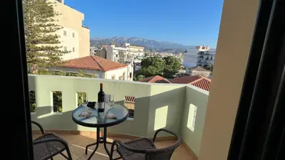 a table with a bottle of wine on a balcony at Eteá Urban Nest living In the Heart of Chania in Chania Town