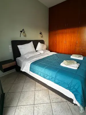 a bedroom with a large bed with a blue blanket at Eteá Urban Nest living In the Heart of Chania in Chania Town