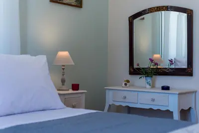 a bedroom with a bed and a mirror on the wall at Villa Remedio in Néon Khoríon