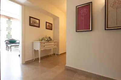 a hallway with a table and pictures on the wall at Nobili Boutique Hotel in Chania Town