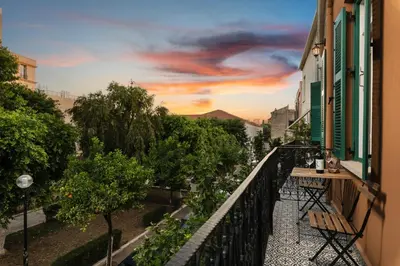 a balcony with a view of a city at sunset at Nobili Boutique Hotel in Chania Town