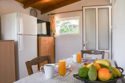 a kitchen with a table with a bowl of fruit on it at Katerina's house in Kefálion