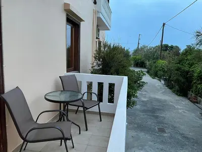 a balcony with two chairs and a table on a porch at Livadia Studios in Ropanianá