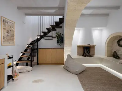 a living room with a staircase and a fireplace at Lithos Retreat (ΛΙTHOS Retreat) in Kolymvari