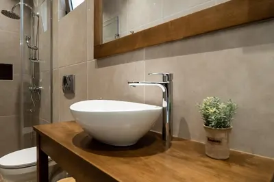 a bathroom with a white bowl sink on a wooden counter at Amalthia Casa by 8essentially in Chania Town