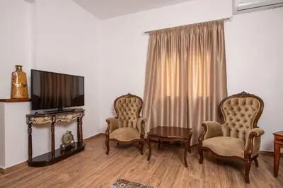 a living room with two chairs and a flat screen tv at Vintage project house in Kalyves