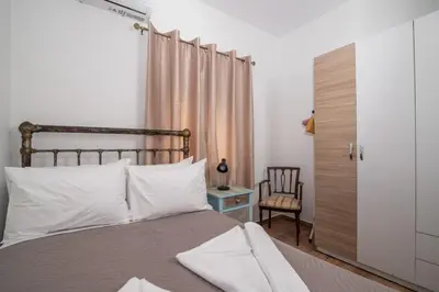 a bedroom with a bed with white pillows and a chair at Vintage project house in Kalyves
