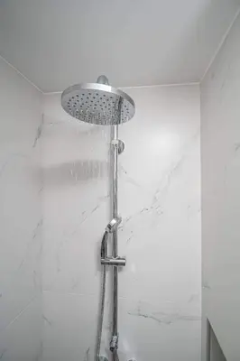 a shower with a shower head in a bathroom at Antigone's Lux Home 10mins walk to beach, old town, city in Chania Town