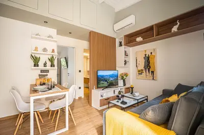 a living room with a couch and a table and a television at Antigone's Lux Home 10mins walk to beach, old town, city in Chania Town