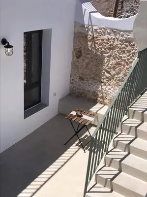 a room with stairs and a table and a window at Lithos Retreat 2(ΛΙTHOS Retreat) in Kolymvari