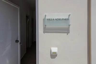 a sign on the side of a building with a wall with a mailbox at Adelphes Beachfront Apartment with direct connection to the beach in Chania Town