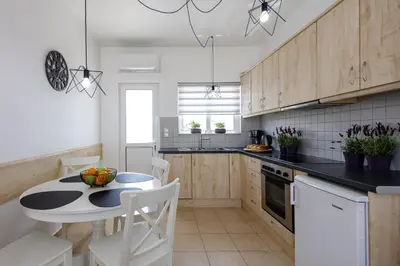 a kitchen with a table and a table and chairs at Adelphes Beachfront Apartment with direct connection to the beach in Chania Town