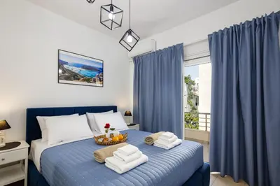 a bedroom with a blue bed with towels on it at Adelphes Beachfront Apartment with direct connection to the beach in Chania Town