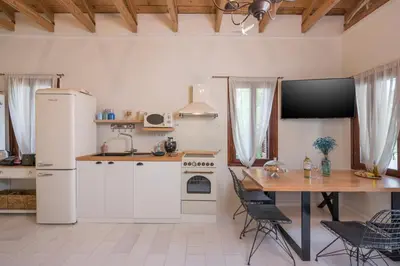 a kitchen with a table and a white refrigerator at Belle Epoque Halepa's House & Studio in Chania Town