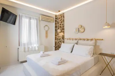 a bedroom with a white bed with towels on it at Belle Epoque Halepa's House & Studio in Chania Town