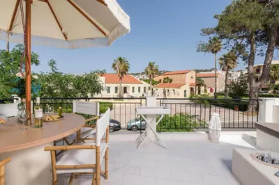 a patio with a table and chairs and an umbrella at Belle Epoque Halepa's House & Studio in Chania Town