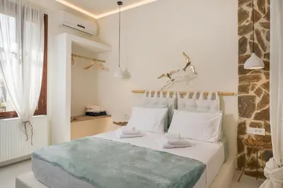 a white bedroom with a large bed with white pillows at Belle Epoque Halepa's House in Chania Town