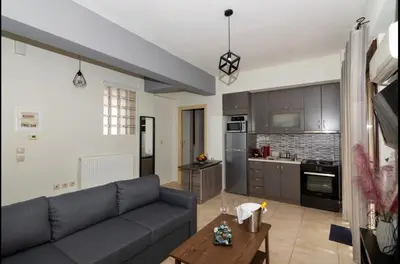 a living room with a couch and a kitchen at Callisto in Chania Town