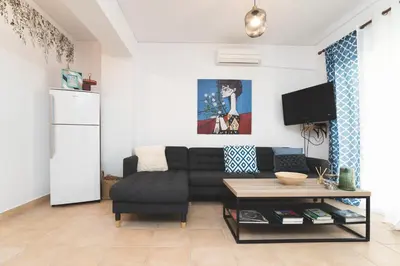 a living room with a black couch and a table at Origeo casa in Maleme