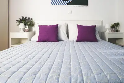 a bedroom with a large bed with purple pillows at Origeo casa in Maleme