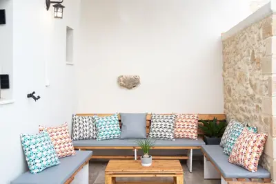 a group of pillows on a patio with benches at Villa Konstantinos in Azoyirás