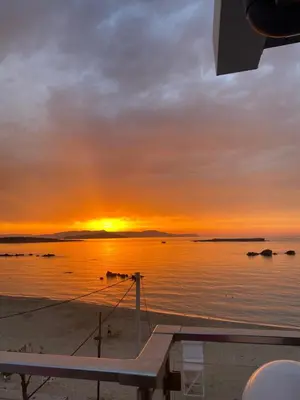 a sunset on a boat in the water at Rika’s seaside apartments in Chania Town