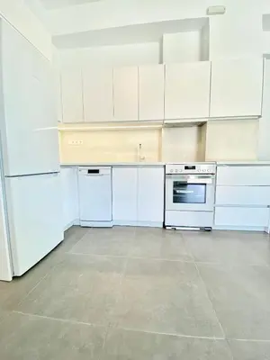 an empty kitchen with white cabinets and appliances at Lefko Apartments in Tavronitis
