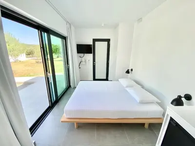 a bedroom with a bed and a large window at Lefko Apartments in Tavronitis