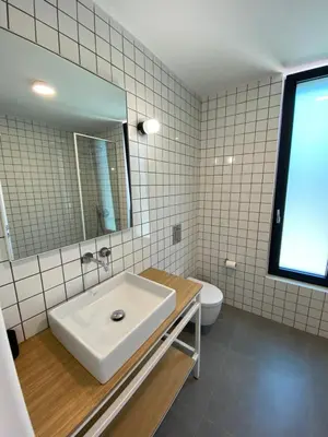a bathroom with a sink and a mirror and a toilet at Lefko Apartments in Tavronitis