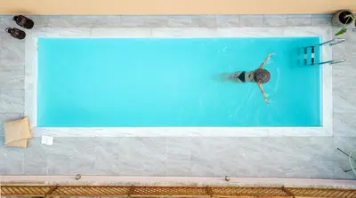 a man swimming in the water in a pool at Arch Houses - Nature Escape with Shared Pool in Spiliá