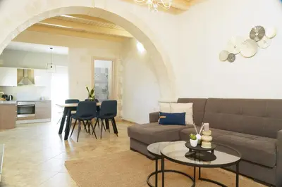 a living room with a couch and a table at Arch Houses - Nature Escape with Shared Pool in Spiliá