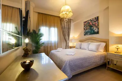 a bedroom with a bed and a table and a window at Epavlis Akrotiri in Chania Town