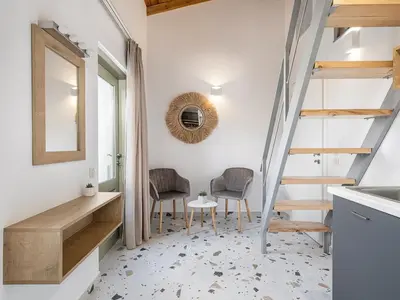 a room with stairs and two chairs and a mirror at Cretan Berry Kondylaki in Chania Town