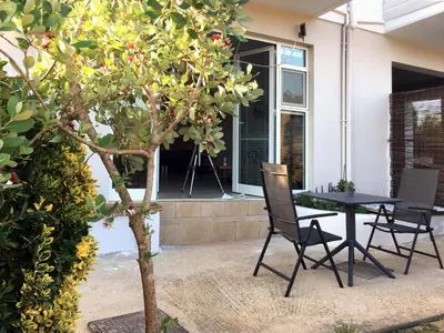 a patio with a table and chairs next to a tree at Livingfy Apt with mountain view & garden in Vamos