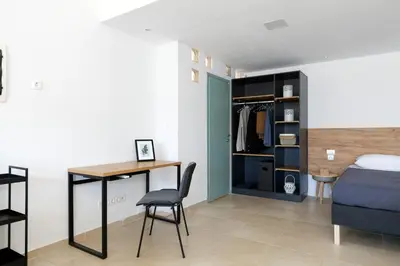 a bedroom with a bed and a desk and a table at Livingfy Apt with mountain view & garden in Vamos