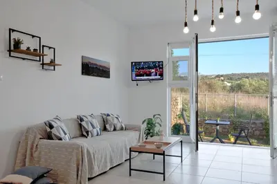 a living room with a couch and a large window at Livingfy Apt with mountain view & garden in Vamos