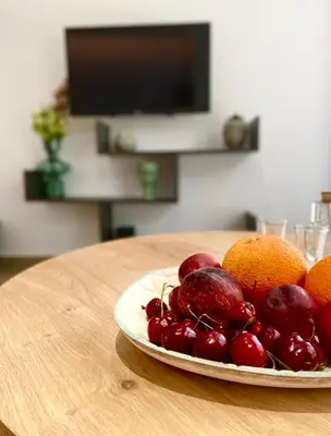 a plate of cherries and oranges on a table at Ivy, 4 minutes from the sea in Chania Town