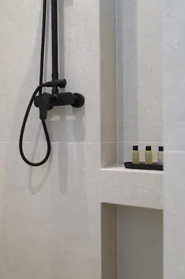 a bathroom with a black shower head on a wall at AGAVE HILL LUXURY HOUSE in Chania Town