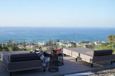a patio with two couches and a table and the ocean at AGAVE HILL LUXURY HOUSE in Chania Town