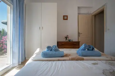 a bedroom with a large bed with blue towels on it at Villa Festos in Voúvai