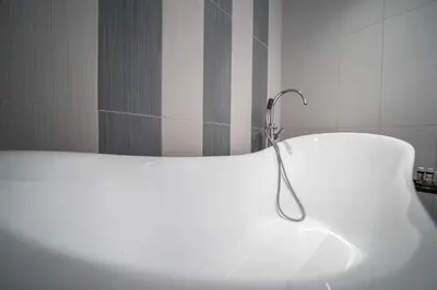 a white bath tub with a faucet in a bathroom at Aiolos Executive Suite in Galatás