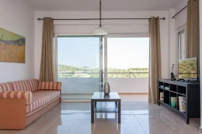 a living room with a couch and a table at Hillside Seaview Apartment in Stalos