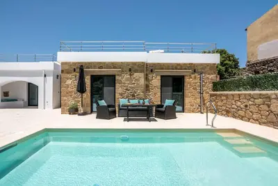 a villa with a swimming pool and a patio at White House Boutique in Koukounará